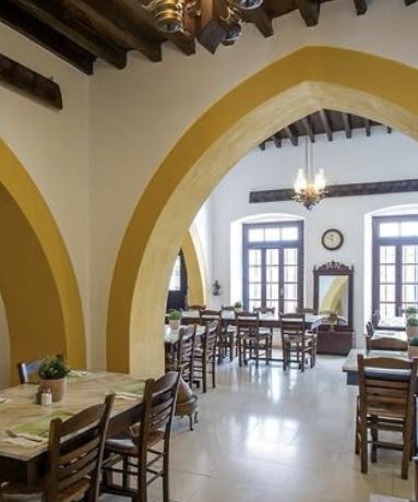 Byzantino Palati restaurant with tall yellow stone arches and wooden tables