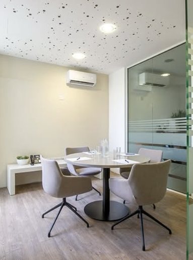 Small meeting room with a round table and grey chairs