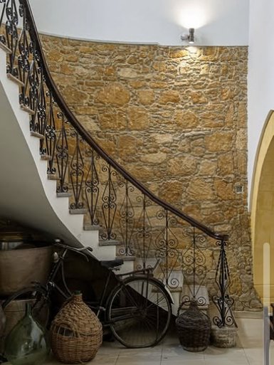Spiral staircase against an exposed stone wall